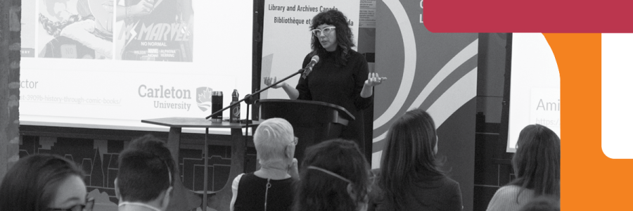 A woman is presenting to an audience of adults.
