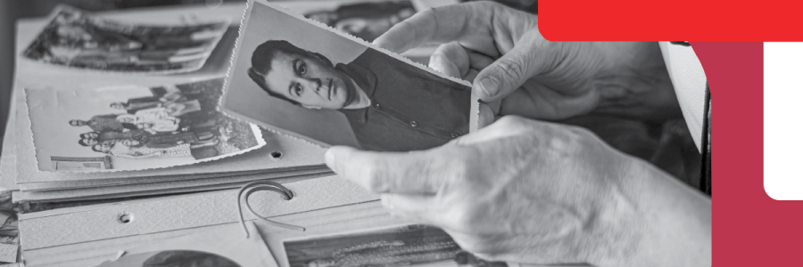 History Research Hands are holding a photo of a woman. There are family and personal photos in the background.