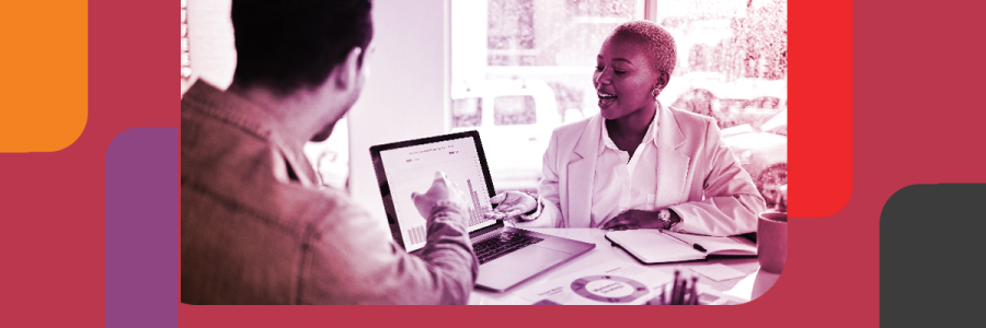 Two professionals, a man and a black woman looking at a laptop screen displaying data charts
